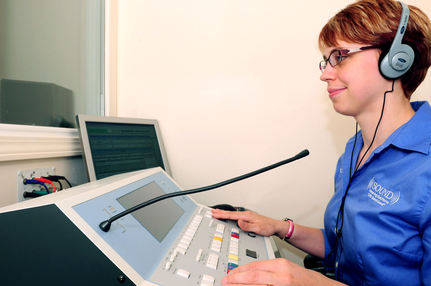 Doctor Conner giving a hearing test in the hearing booth